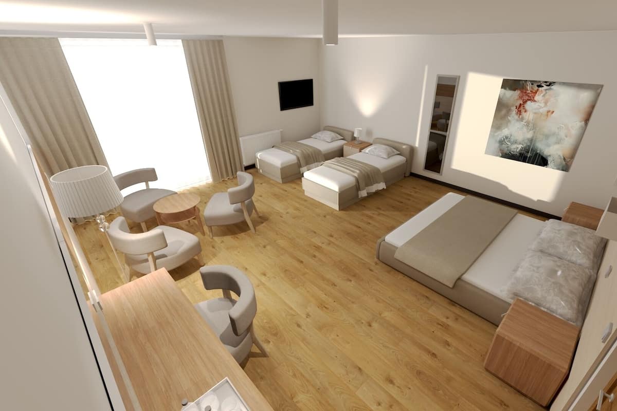 A modern hotel room with a wooden floor, a sofa bed, a desk, a chair, a small table, and a painting on the wall.