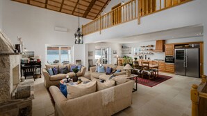 A spacious living area with a high ceiling, a fireplace, and a dining area with a red rug. - Exclusive and private Villa, seaside in Vinisce, 30 min from Split airport (Vinišće)