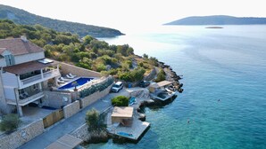 A coastal property with a swimming pool, a boat dock, and a scenic view of the sea and hills. - Exclusive and private Villa, seaside in Vinisce, 30 min from Split airport (Vinišće)