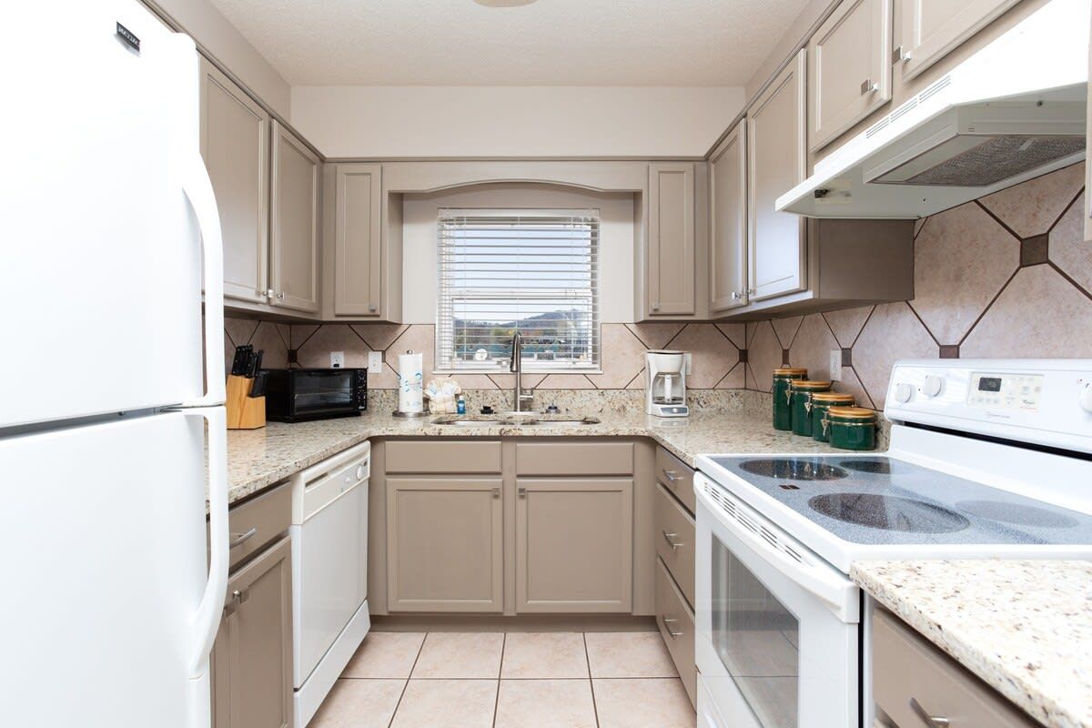 A kitchen with a built-in oven, microwave, and sink.
