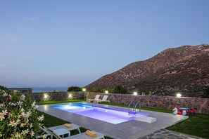 A swimming pool with a stone wall, lounge chairs, and a view of the sea. - Dream Villa Violeta, Cretan Gem with SeaViews (Bali, Rethymno)