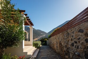 Stroll through lush gardens to a serene retreat, surrounded by vibrant flowers and a majestic mountain backdrop.