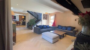 A spacious living area with a staircase, a sofa set, and a coffee table.