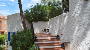 A set of outdoor stone steps leading up to a white wall, with lanterns placed along the path. - Villa with private pool very close to the beach.Capacity 8 people. Wifi. (pals)