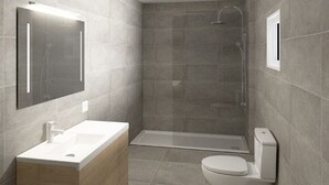 Une salle de bain moderne équipée d’une douche, de toilettes et d’un lavabo.