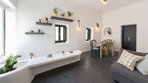 Een moderne woonkamer met een inbouwbank, een eethoek met een tafel en stoelen, en een donkere deur.