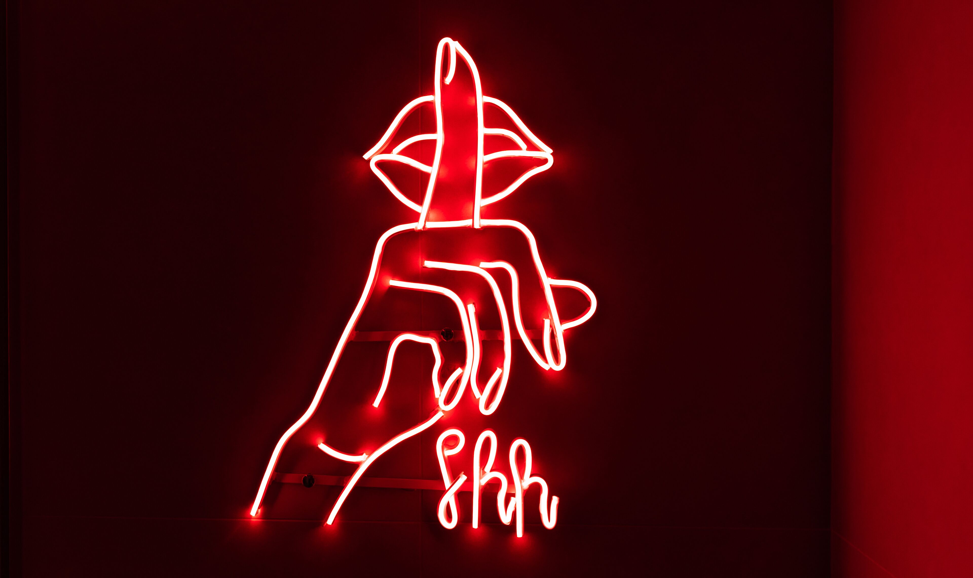 A neon sign with a stylized figure and the text "8huh".