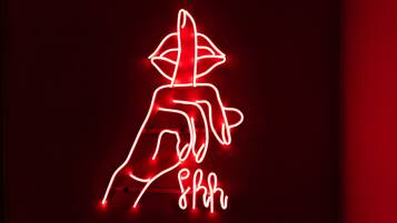 A neon sign with a stylized figure and the text "8huh".