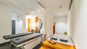 A modern bathroom with a massage table, a large bathtub, and a wooden vanity. - Amon Hotel Belek - All Inclusive (Serik)