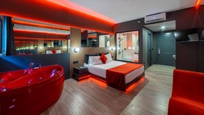 A modern hotel room with a large bed, a red bathtub, and a bathroom with a shower. - Amon Hotel Belek - All Inclusive (Serik)