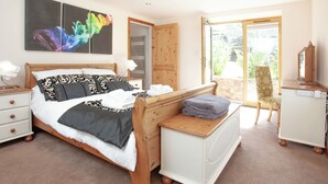 A bedroom with a bed, bedside table, dresser, and a view of the outdoors. - 3 bedroom accommodation in Butterleigh, near Tiverton (Butterleigh, near Tiverton)