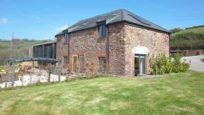 A stone building with a sloped roof, a door, and a window. - 3 bedroom accommodation in Butterleigh, near Tiverton (Butterleigh, near Tiverton)