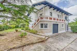 A two-story house with a stone facade, a blue roof, and a small front garden. - Villa Le Deck - Grande maison familiale proche plage (Arcachon)