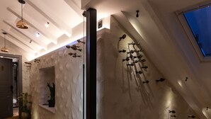 Un intérieur moderne avec un plafond en pente, un plancher en bois et un puits de lumière.