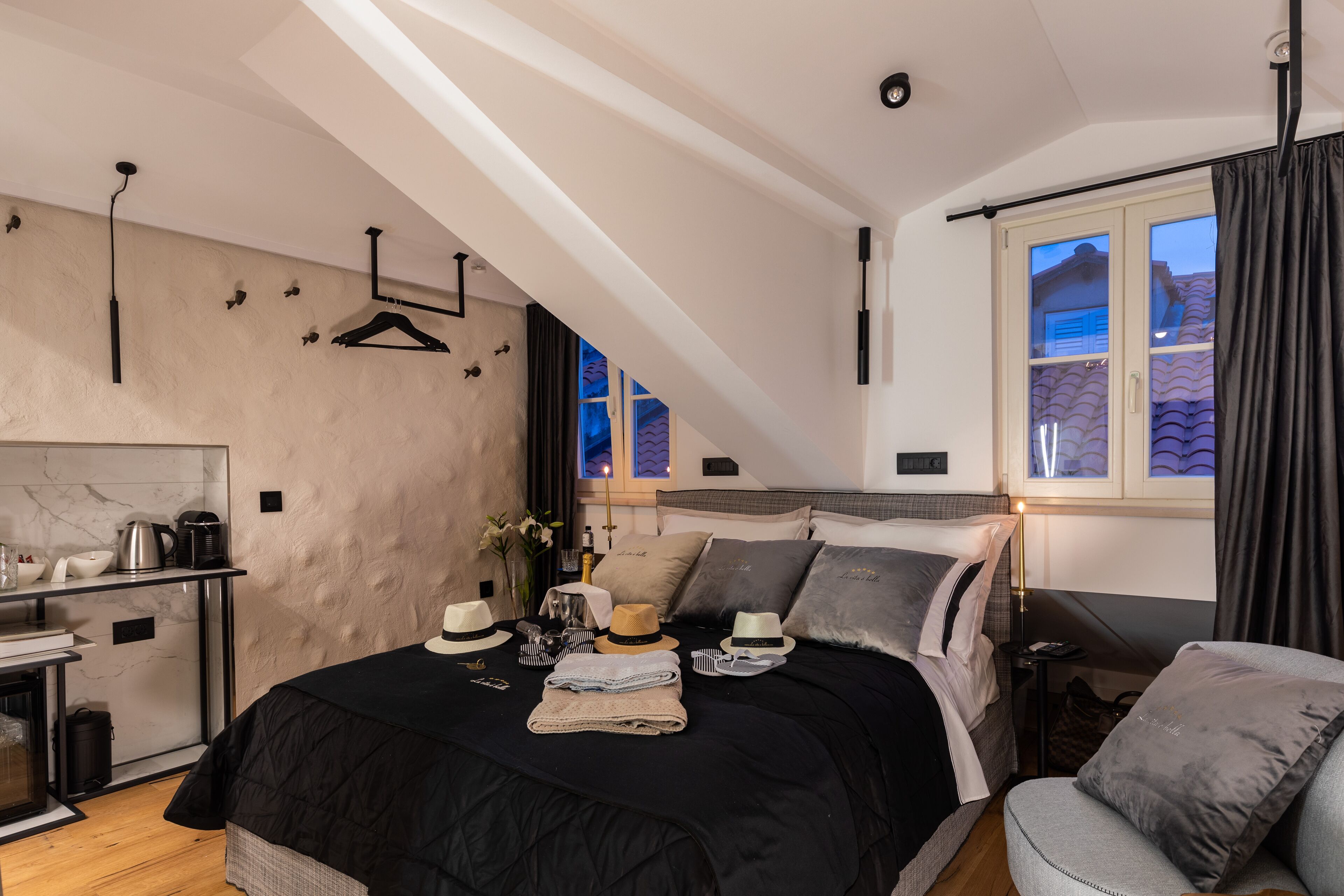Een slaapkamer met een bed, een stoel, een bureau en een raam met gordijnen.