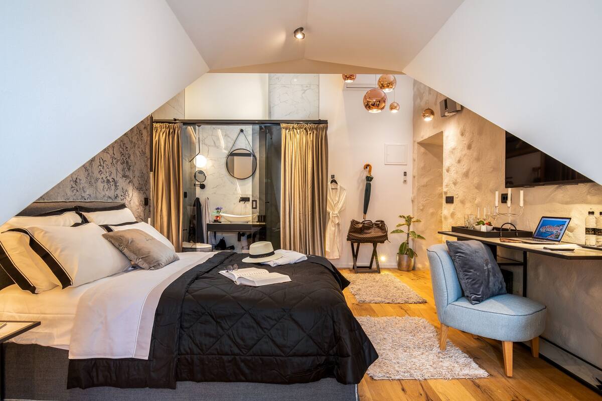 Ein Schlafzimmer mit Bett, Schreibtisch, Stuhl und Bad.