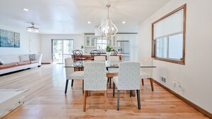A spacious dining area with a chandelier, a white dining table, and patterned chairs. - Modern Home Near The Battery Truist Park & Marietta Square Steam Shower Sleeps 8 (Marietta)