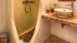 Ein Badezimmer mit Dusche, Waschbecken und Spiegel.