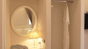 Ein Badezimmer mit weißem Waschtisch, einem Spiegel, einem Handtuchhalter und einer Duschkabine.