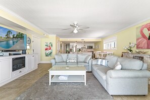 Una sala de estar con piscina, comedor y cocina.