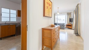 A modern kitchen with wooden cabinets, a built-in dishwasher, and a large window.
