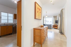 Eine moderne Küche mit Holzschränken, einem integrierten Geschirrspüler und einem großen Fenster.