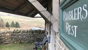 Un mur de pierres, un banc et une pancarte indiquant « RAMBLERS REST ».