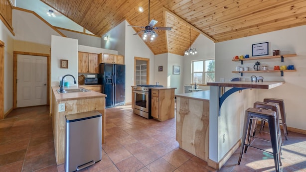 A spacious kitchen with wooden cabinets, a central island, and a built-in oven. - Spacious Farm House with Stunning Mountain Views (Joseph)