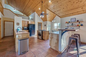A spacious kitchen with wooden cabinets, a central island, and a built-in oven. - Spacious Farm House with Stunning Mountain Views (Joseph)