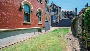 A red brick building with arched windows and a small grassy yard. - Business Suite  - Walkable Entertainment (Pittsburgh)