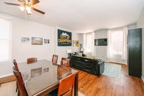 Relax in this stylish living area with a large dining table, comfortable sofa, and flat-screen TV.