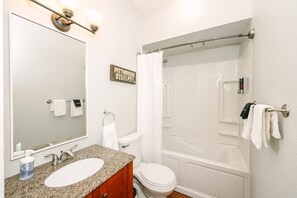 Bathtub, hair dryer, towels, shampoo