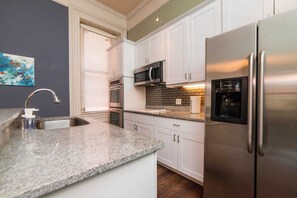 A kitchen with white cabinets, stainless steel appliances, a granite countertop, and a window with blinds. - Unbeatable Location - Walkable Entertainment (Pittsburgh)