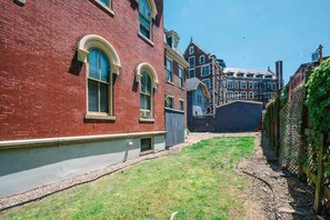 A red brick building with arched windows and a small grassy yard. - Unbeatable Location - Walkable Entertainment (Pittsburgh)