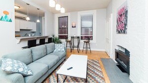 A modern living room with a sofa, coffee table, and a fireplace. - Central Location Suite - Walkable Entertainment (Pittsburgh)