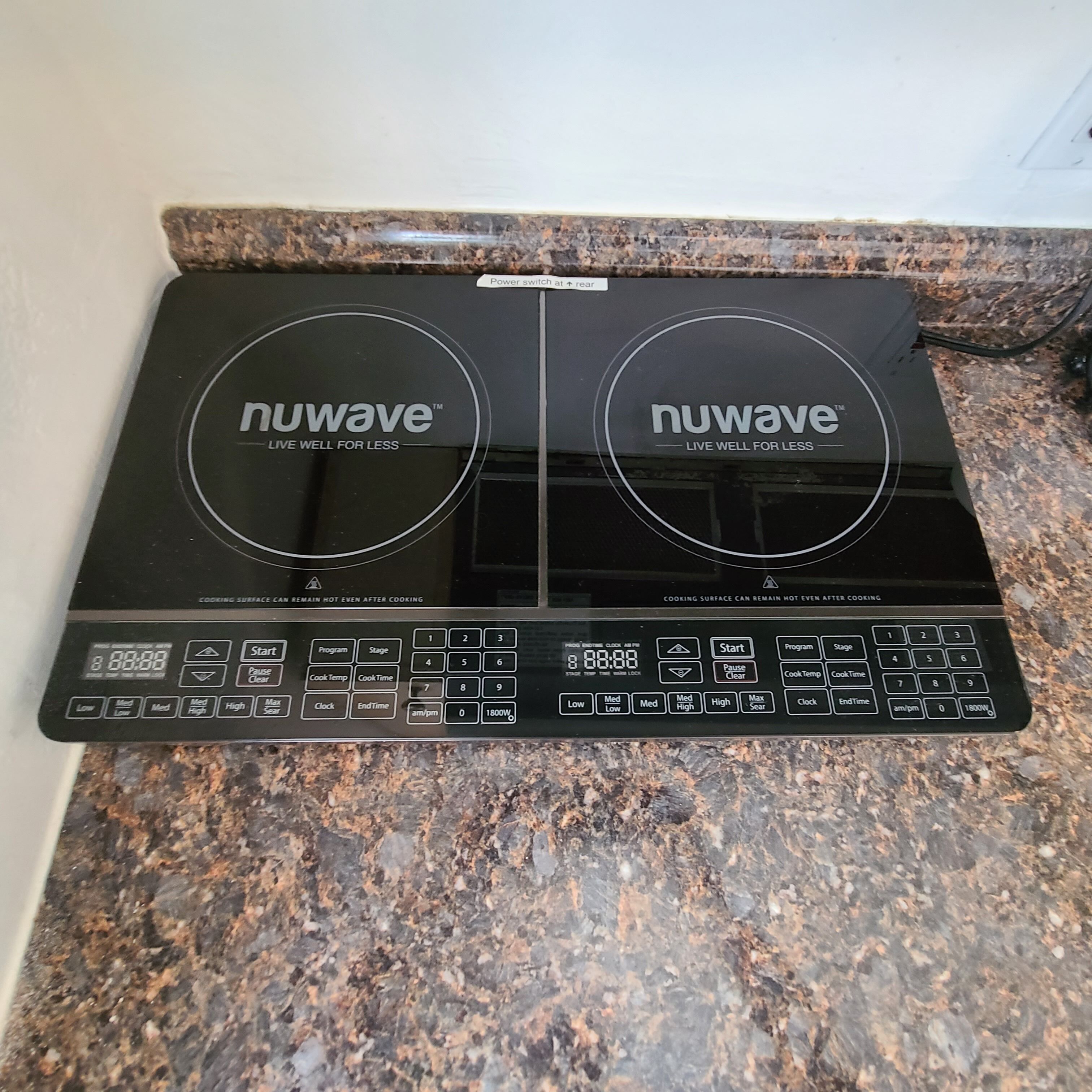 A Nuwave induction cooktop with a digital display and multiple cooking settings.