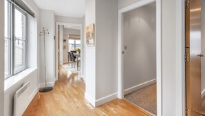 A hallway with wooden flooring, white walls, and a door leading to a dining area. - Eleven Popeshead - 2 bed, 2 bath central apartment (York)