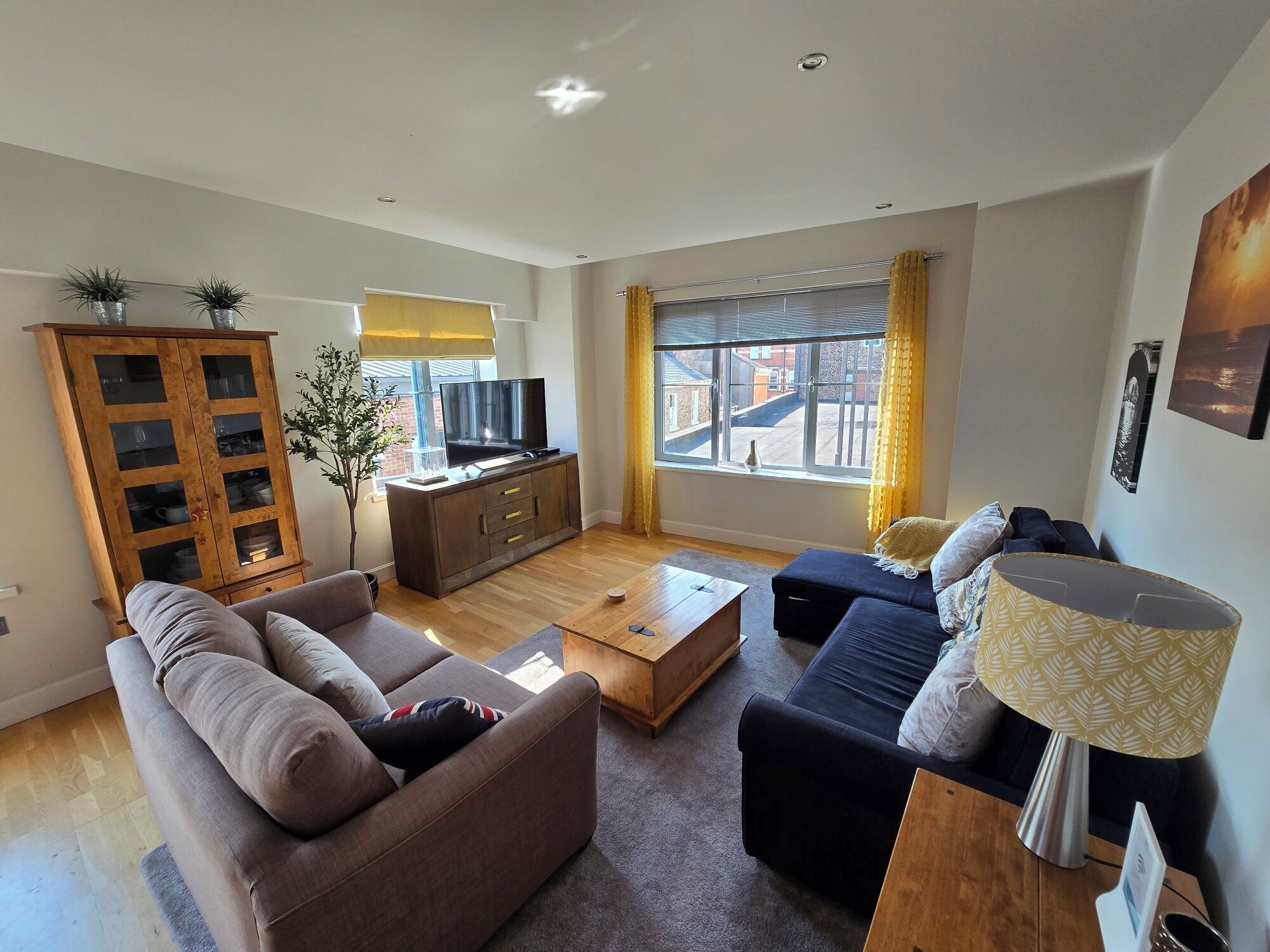 A modern living room with a sofa, coffee table, TV, and a cabinet.