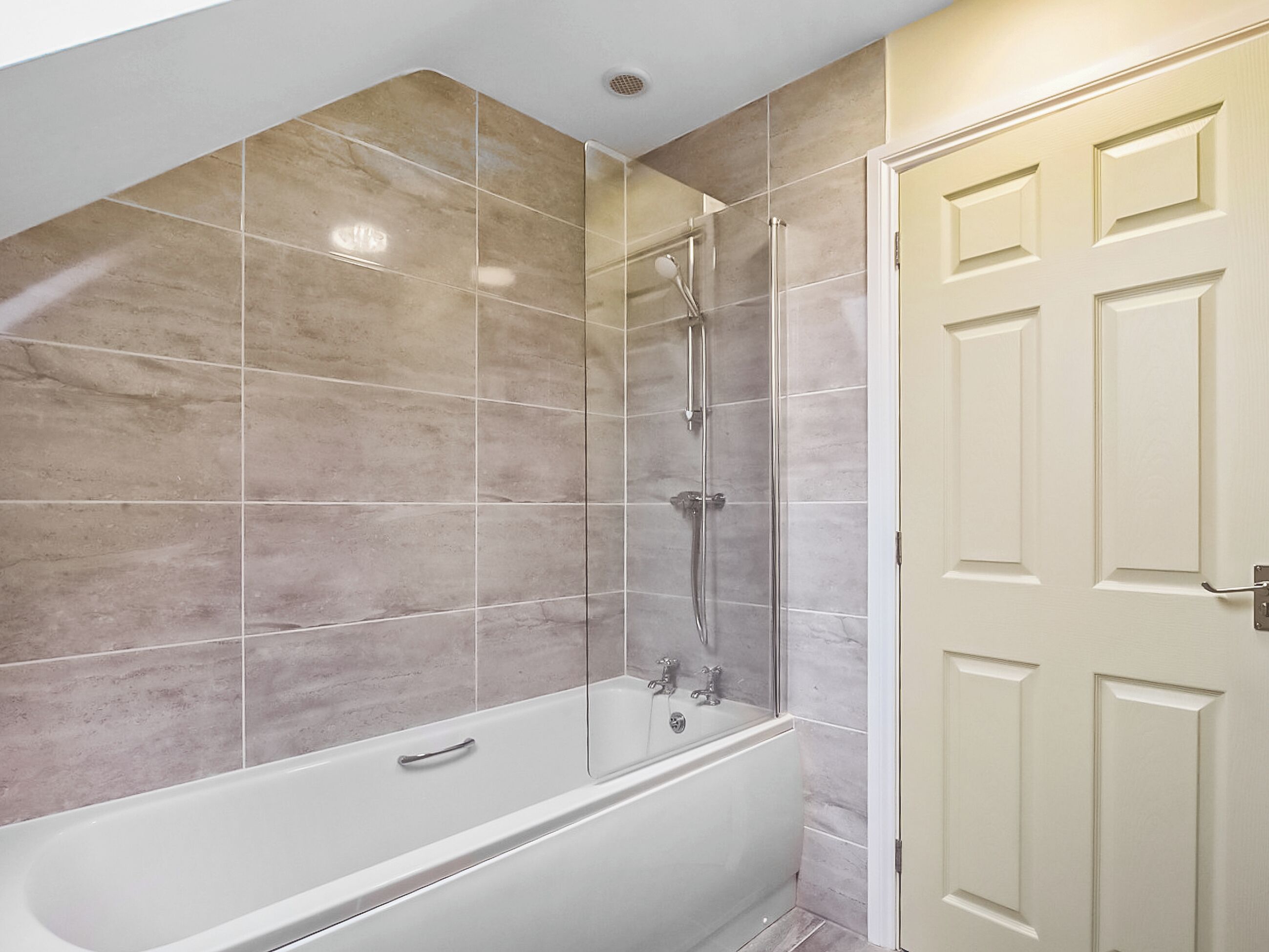 Une salle de bain avec une baignoire, une douche et une porte.