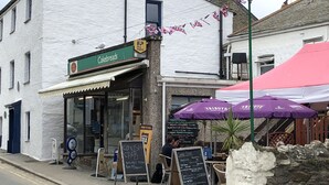 Eine Bäckerei namens 'Cakebreads' mit Außenbestuhlung und einem Schild 'Coffee Stop'.