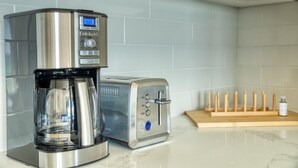 Una cafetera y un tostador sobre la encimera de la cocina.
