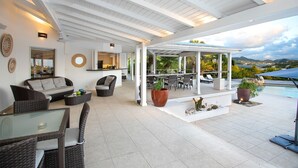 Eine geräumige Terrasse mit Korbmöbeln, einem Glastisch und Meerblick.