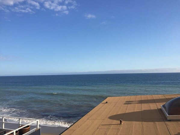 Eine Terrasse mit Blick auf das Meer und ferne Berge.