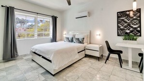 A modern bedroom with a bed, bedside tables, a desk, and a chair. - Best Beach Location | Wi-Fi, TV & Amenities (Miami Beach)