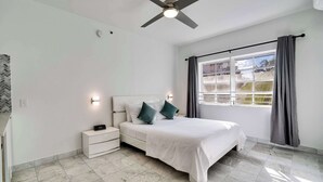 Una camera da letto con un letto, un comodino e una ventola a soffitto.