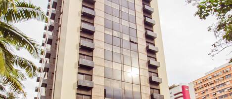 Un edificio alto y moderno con fachada de vidrio y varios balcones.