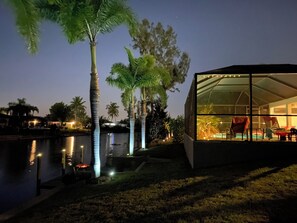 Ein modernes Gebäude mit großen Glasfenstern, einem Pool und Palmen.
