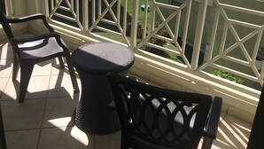 A balcony with two chairs and a small round table, overlooking a body of water and greenery. - OCEAN VIEW COSTA BONITA (Culebra)