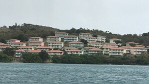 A coastal residential area with multiple multi-story buildings, likely hotels, situated on a hillside with a view of the sea. - OCEAN VIEW COSTA BONITA (Culebra)