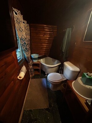 A compact bathroom with a toilet, bidet, and a small sink.